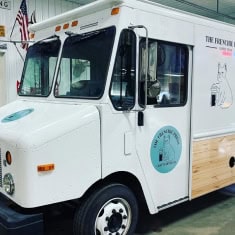 White ice cream truck available at I39 Supply, featuring a wooden panel design and branding for a mobile ice cream business. Perfect for entrepreneurs seeking a reliable, eye-catching vehicle.