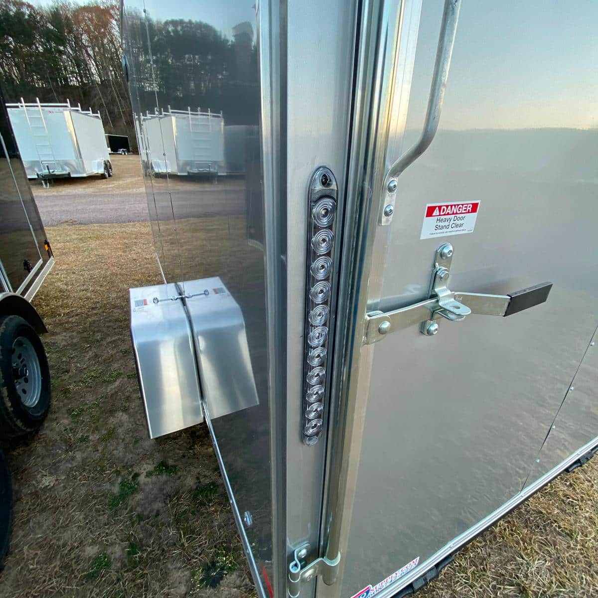 Close-up of trailer door latch and LED lights at I39 Supply trailer dealership, showcasing durable construction and safety features.