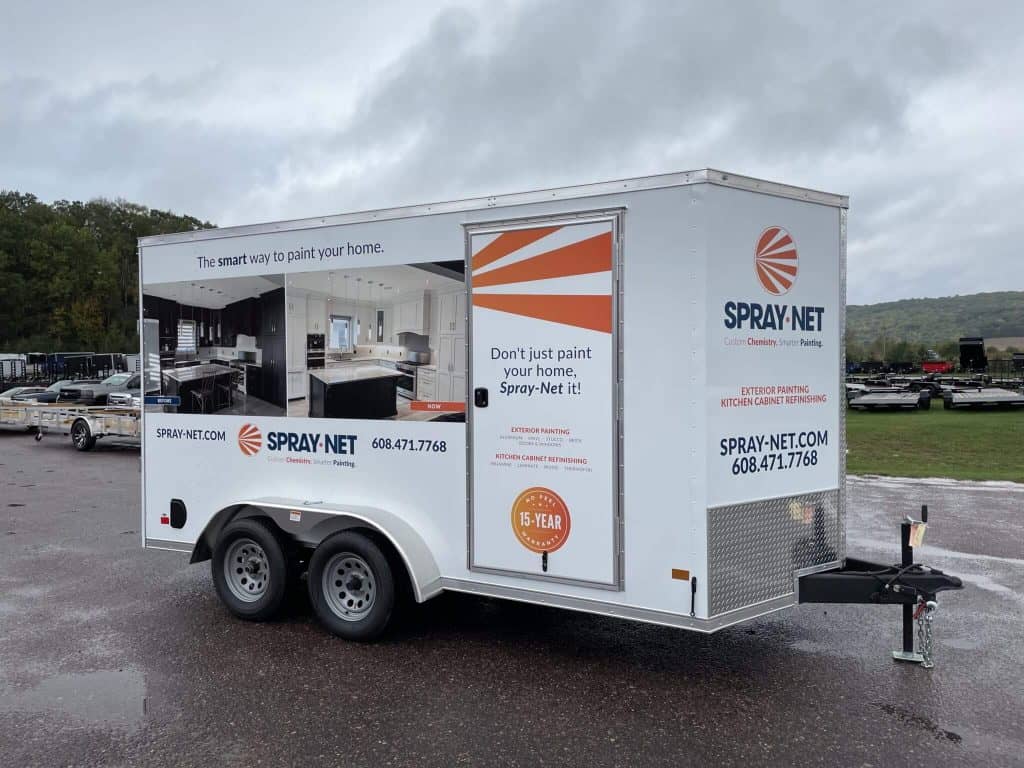Mobile paint trailer by Spray-Net for home exterior painting, featuring branding and contact info, ideal for on-site residential painting projects.
