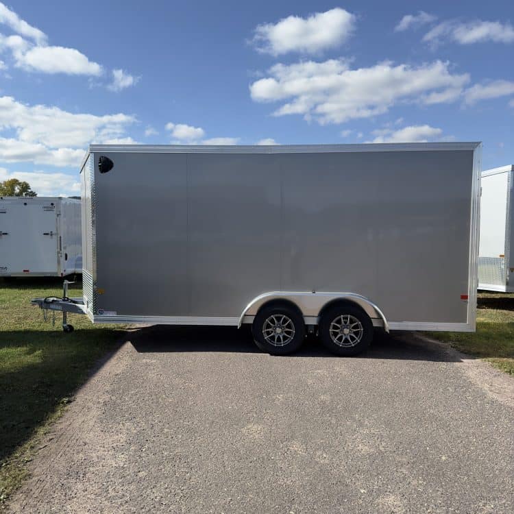 Enclosed trailer with tandem axles, ideal for transporting equipment and goods, featuring a sleek gray exterior and durable construction. Perfect for personal or commercial use.