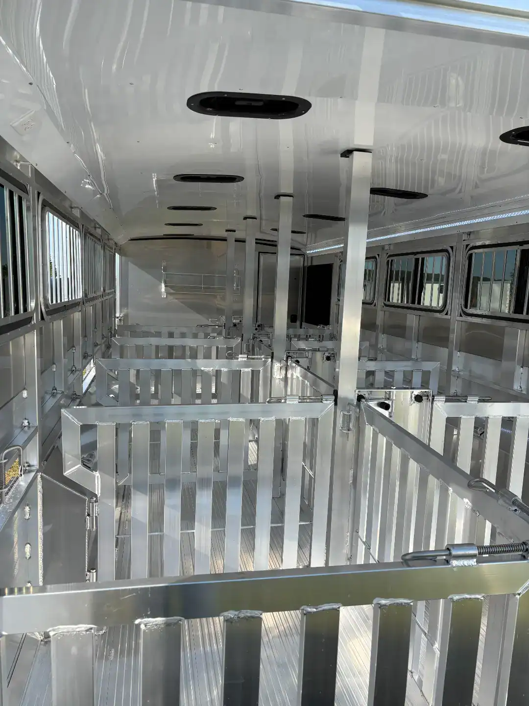 High-quality aluminum livestock trailer with spacious interior, rear and side ramps, and a tack room for efficient animal transport. Perfect for farm and ranch use.