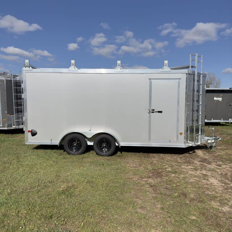 White enclosed utility trailer with dual axles, side door, and rear ramp, ideal for equipment transport and storage.