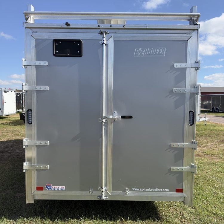Heavy-duty gray EZ Hauler enclosed trailer with rear doors, ideal for cargo transport and storage, displayed outdoors at I39 Supply trailer dealership.