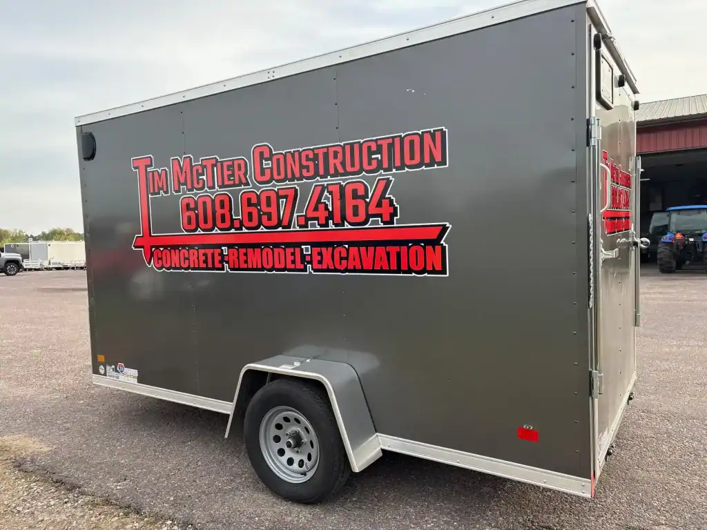 Mobile trailer for construction services with contact info and branding.