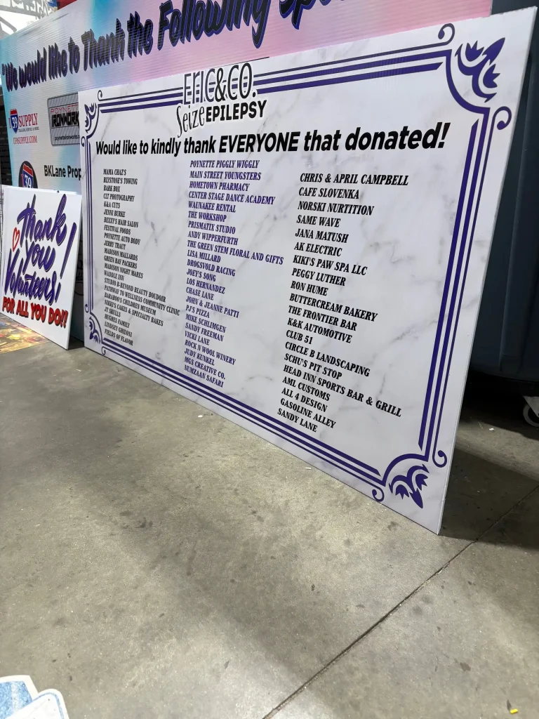Supporters and donors listed on the large donation acknowledgment board at I39 Supply Trailer Dealership.