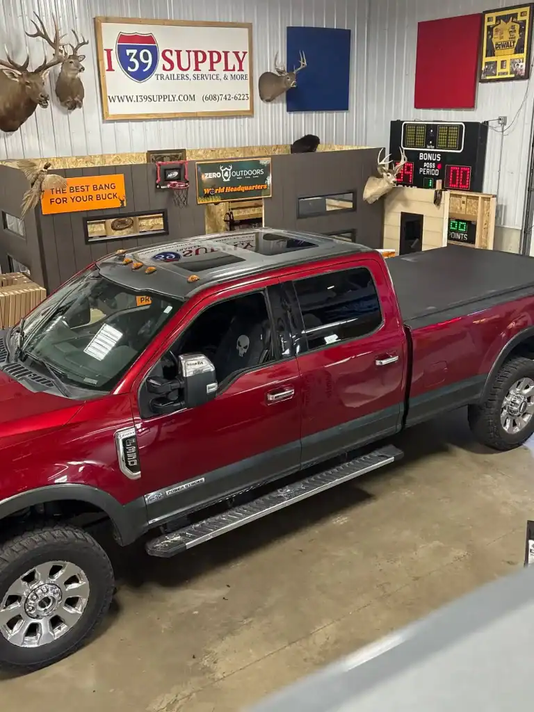Trailer dealership showcasing a variety of trailers and accessories, featuring a red pickup truck inside the showroom.