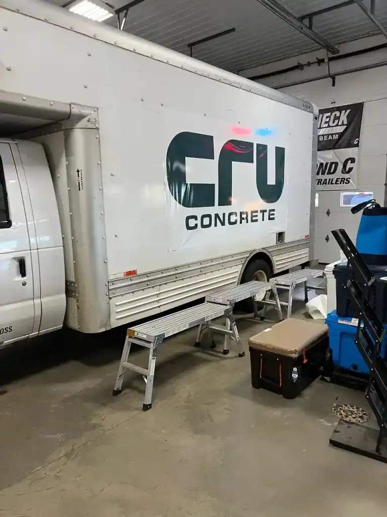 Commercial concrete trailer with I39 Supply branding inside a warehouse, showcasing equipment and tools for trailer customization and sales.