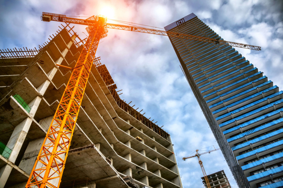 Construction site with cranes and high-rise building under development.