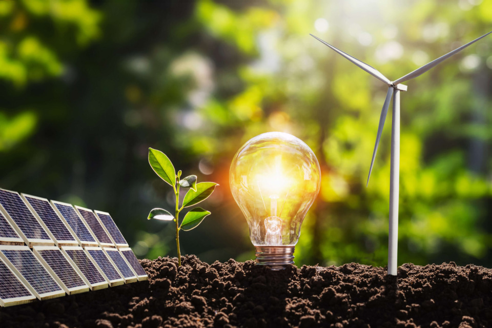 Solar panels, wind turbine, and light bulb representing renewable energy.