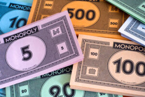 Money and board game currency for Monopoly, including bills of various denominations.
