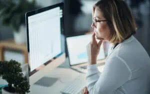 Businesswoman analyzing SharePoint data on computer screen.