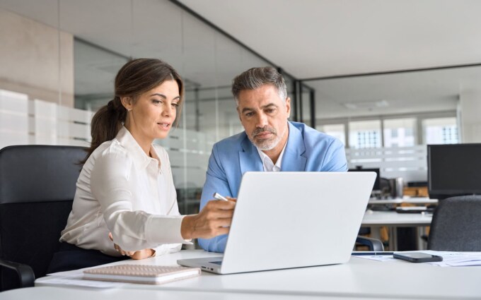 Business professionals using cloud-based access control system on laptop.