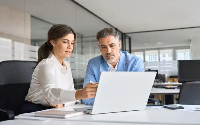 Business professionals using cloud-based access control system on laptop.