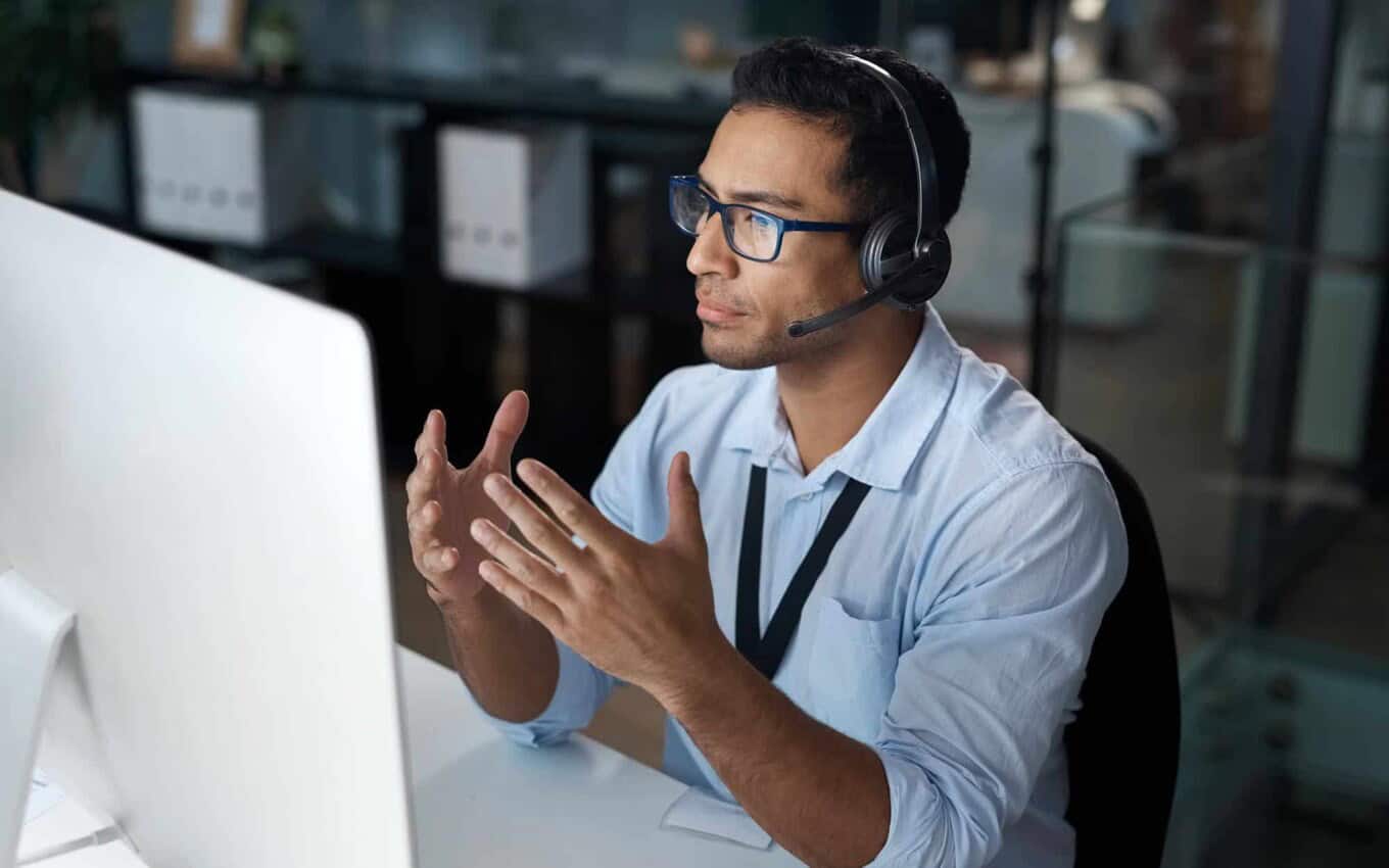 Business professional discussing IT staff augmentation strategies at a computer.