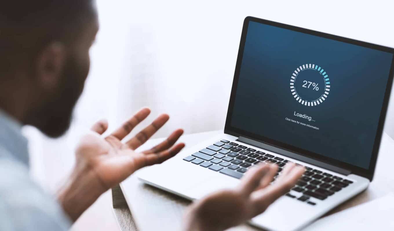 Business analyst reviewing IT system performance on a laptop screen.