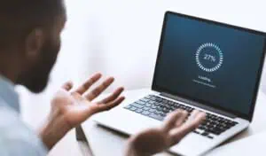Business analyst reviewing IT system performance on a laptop screen.