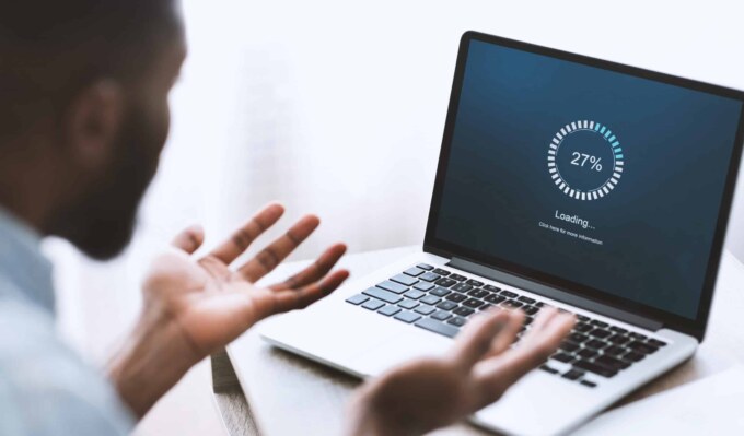 Business analyst reviewing IT system performance on a laptop screen.
