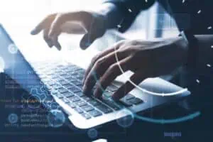 Business professional coding on laptop for web app development.