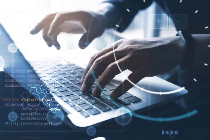 Business professional coding on laptop for web app development.