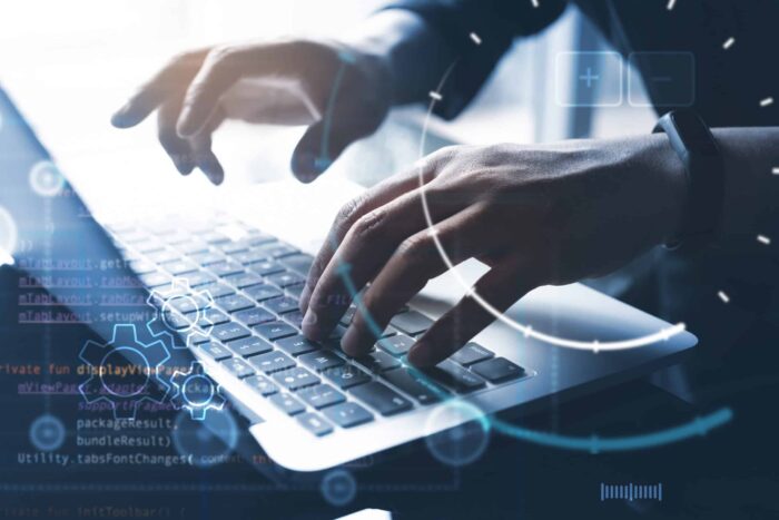 Business professional coding on laptop for web app development.
