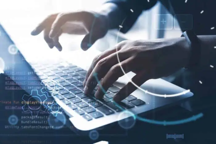 Business professional coding on laptop for web app development.
