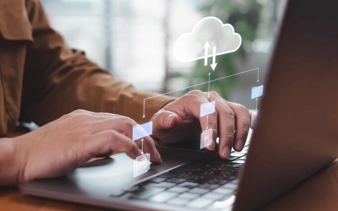 Business professional working on cloud technology with digital icons and cloud graphics.