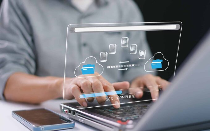 Business professional managing cloud data transfer on a transparent digital screen.