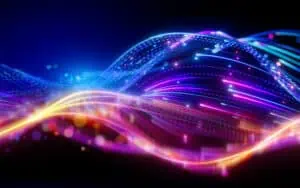 Abstract neon light waves in blue, pink, and yellow against a dark background, suggesting digital motion and energy.