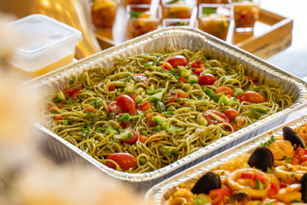 Noodles garnished with tomatoes and vegetables, perfect for vegetarian catering.