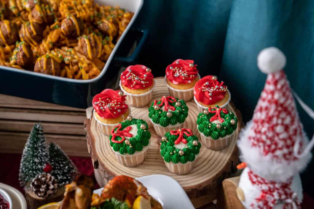a festive assortment of red and green christmas cupcakes by idocatering