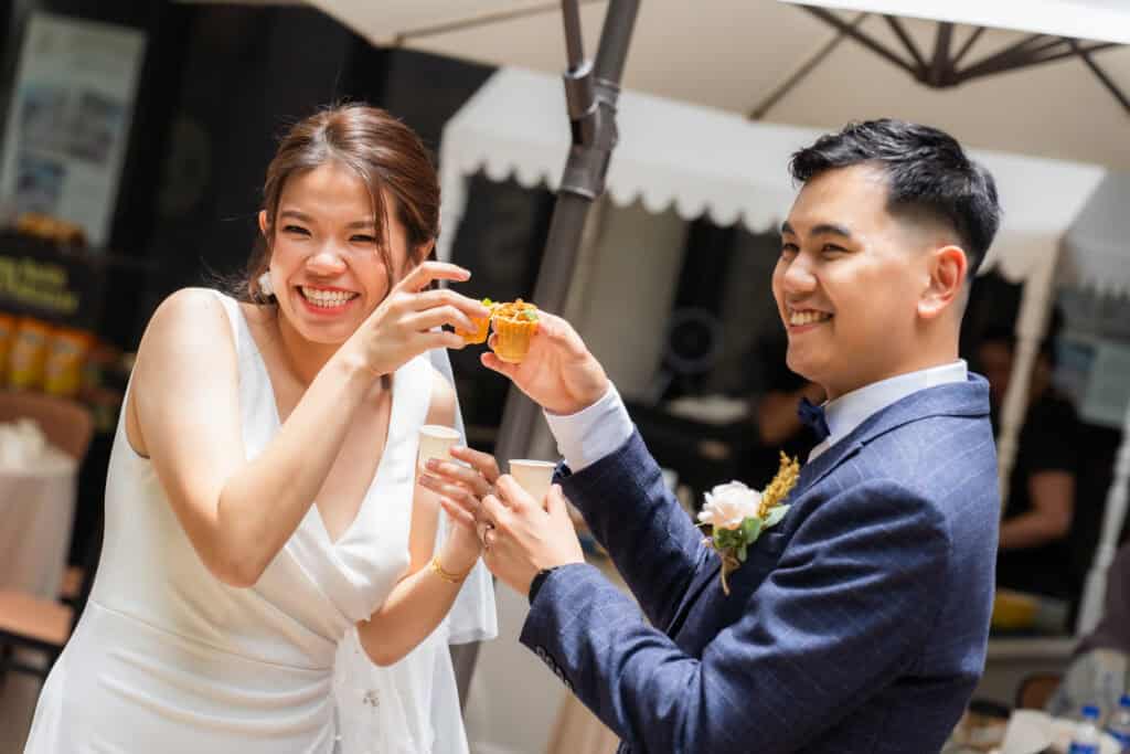 Bride and groom smiling towards the camera during a wedding catering event at Cyberjaya 