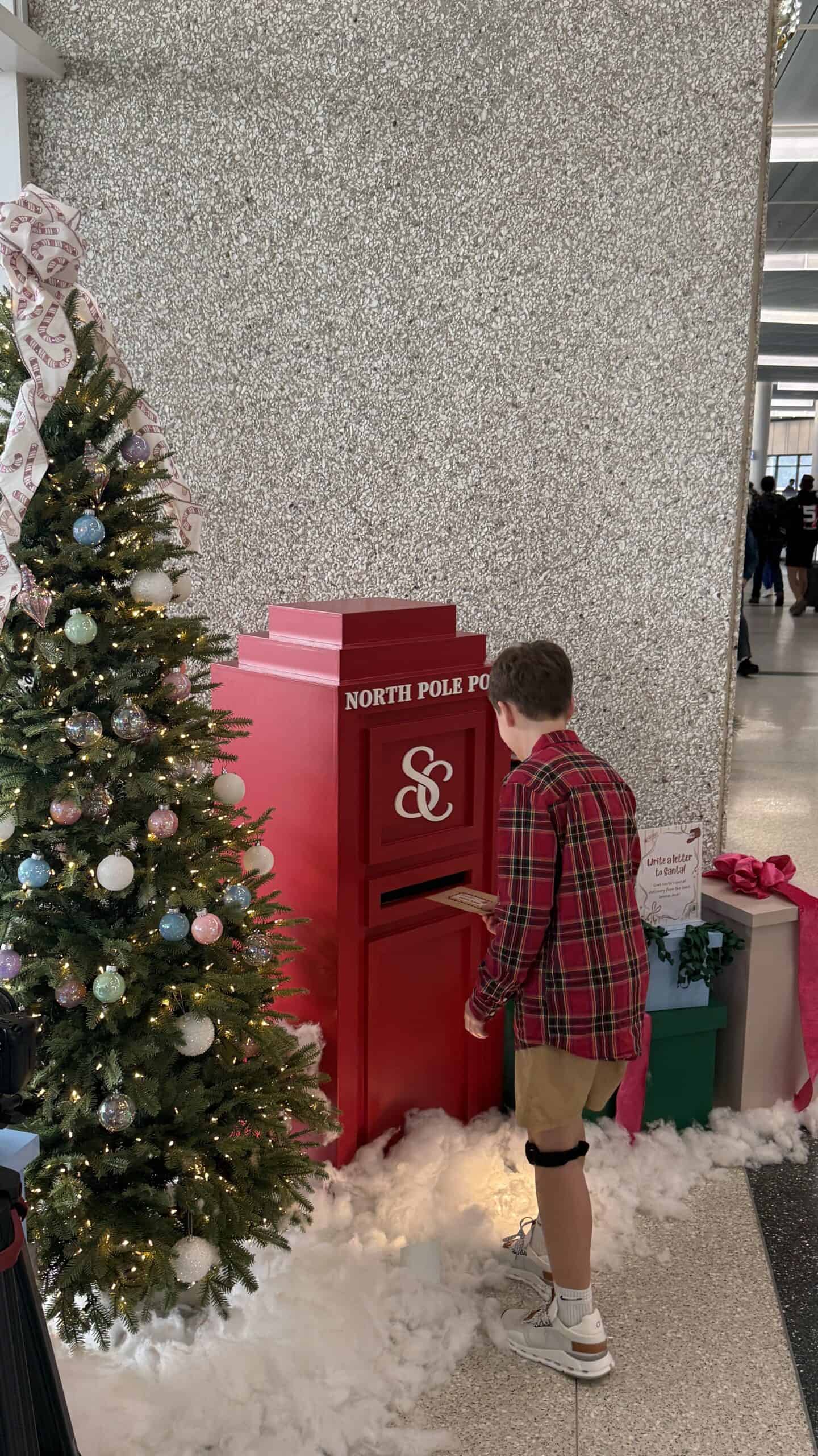 Child placing letter to Santa in Mailbox
