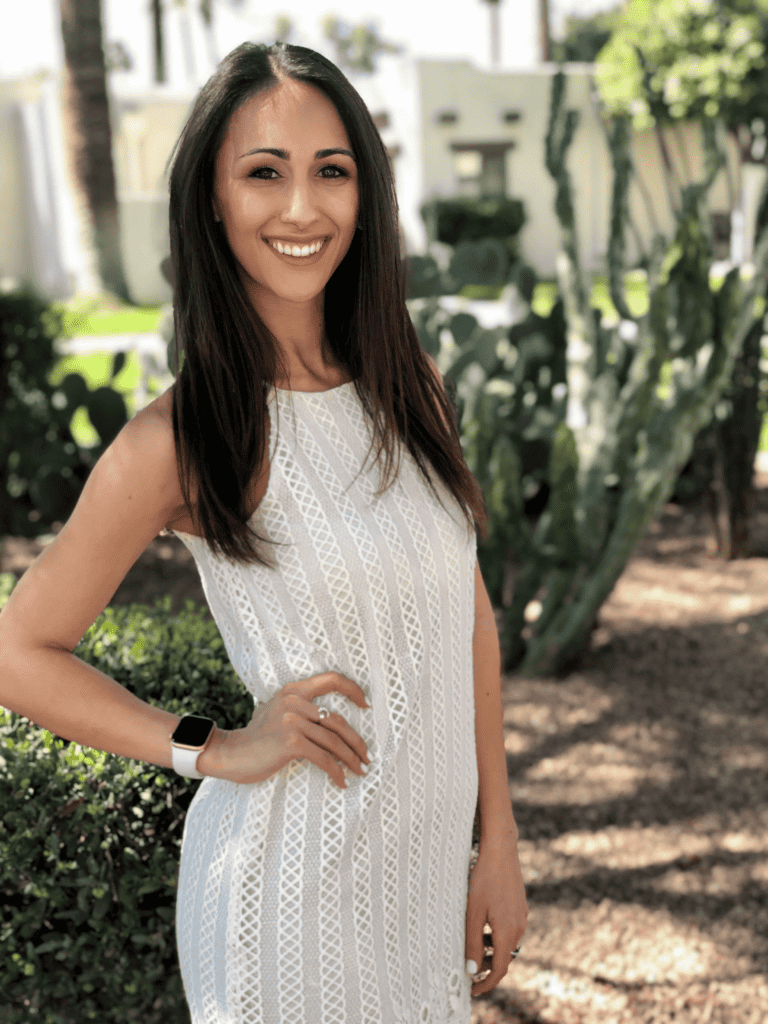 Smiling female staff member at Impact Physical Therapy outdoors.