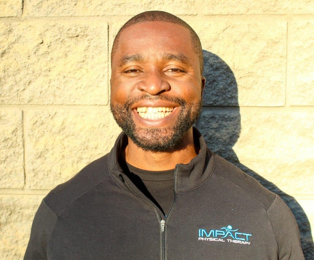 Dr. Uche Nwambuonwo smiling outdoors in Impact PT jacket.