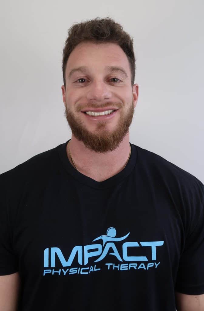 Smiling physical therapist in Impact PT T-shirt for SEO.