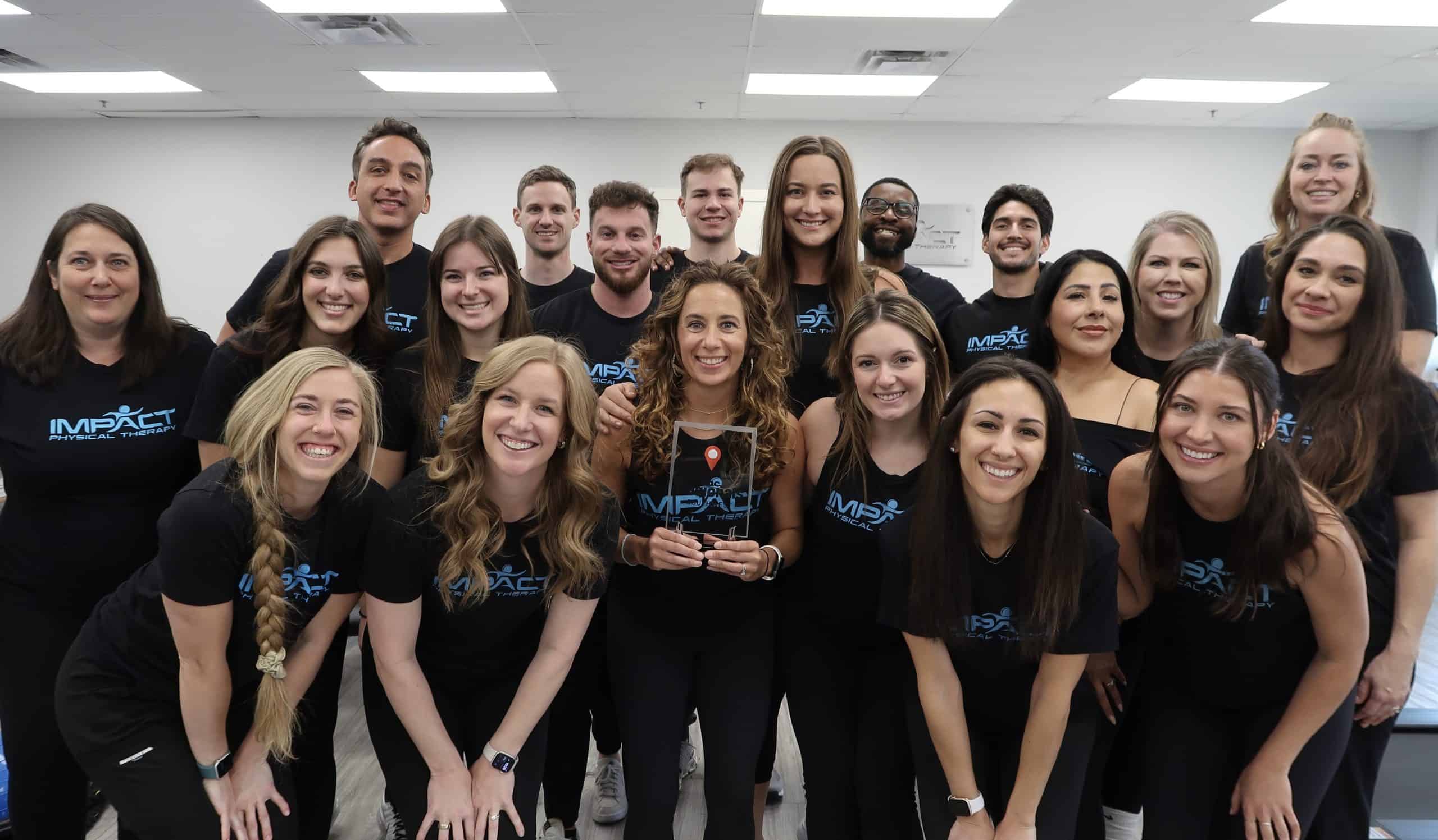 Impact Physical Therapy team group photo in clinic setting.