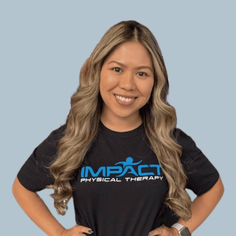 Smiling woman in Impact Physical Therapy T-shirt for health and wellness.
