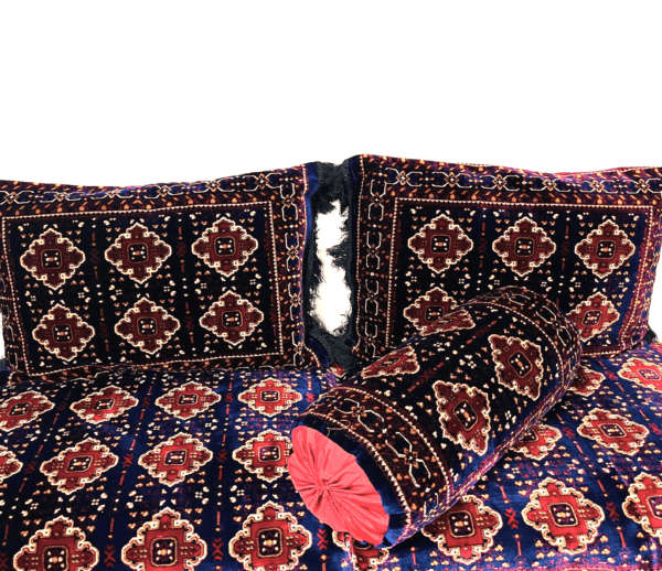 Decorative Pillows And Bolster With Intricate Geometric Pattern In Deep Blues, Reds, And White Accents.