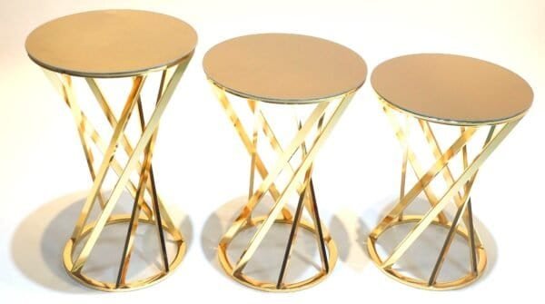 Three Gold-Toned Side Tables With Circular Tops And Intertwined Geometric Bases.