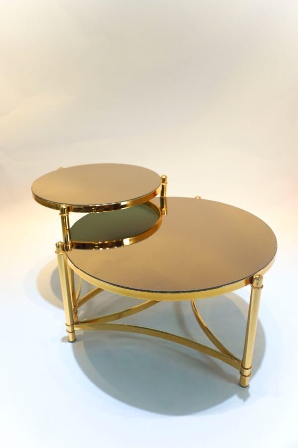Two Gold Round Nesting Tables With Mirrored Tops And Slender Interconnected Legs.