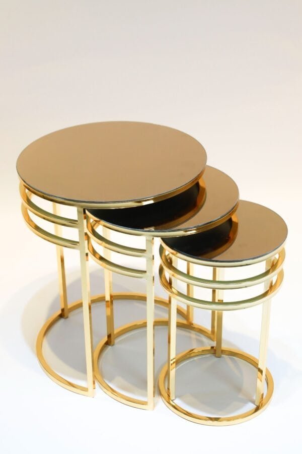 Set Of Three Gold Nesting Tables With Round Tops In A Compact Design.