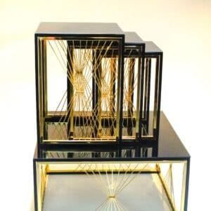 Nested black rectangular frames with gold accents and geometric string patterns.