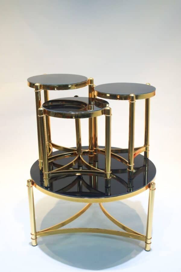 Nested Tables With Round Black Glass Tops And Gold Metal Frames, Arranged In Stacked Form.