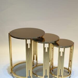Three nested round tables with gold frames and dark reflective tops, varying in size.
