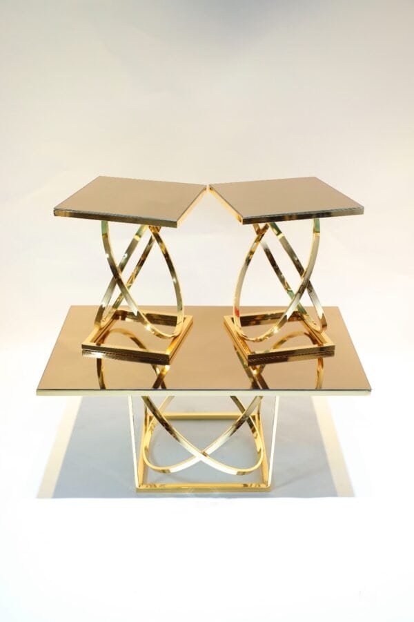 Reflective Gold Tables With Geometric Legs, Tiered Arrangement Of Two Smaller On Larger.