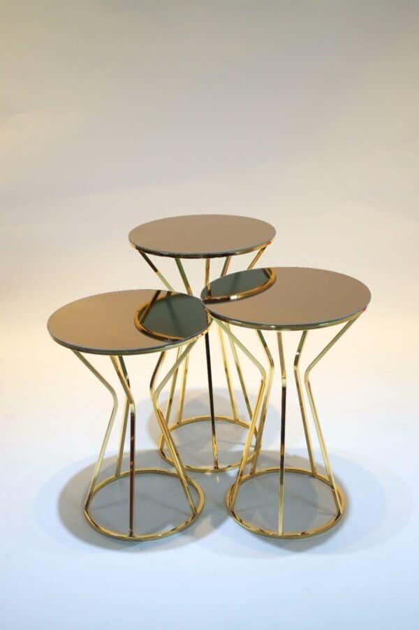 Three Round Nesting Tables With Mirrored Tops, Gold Metal Frames, Arranged In A Cluster.