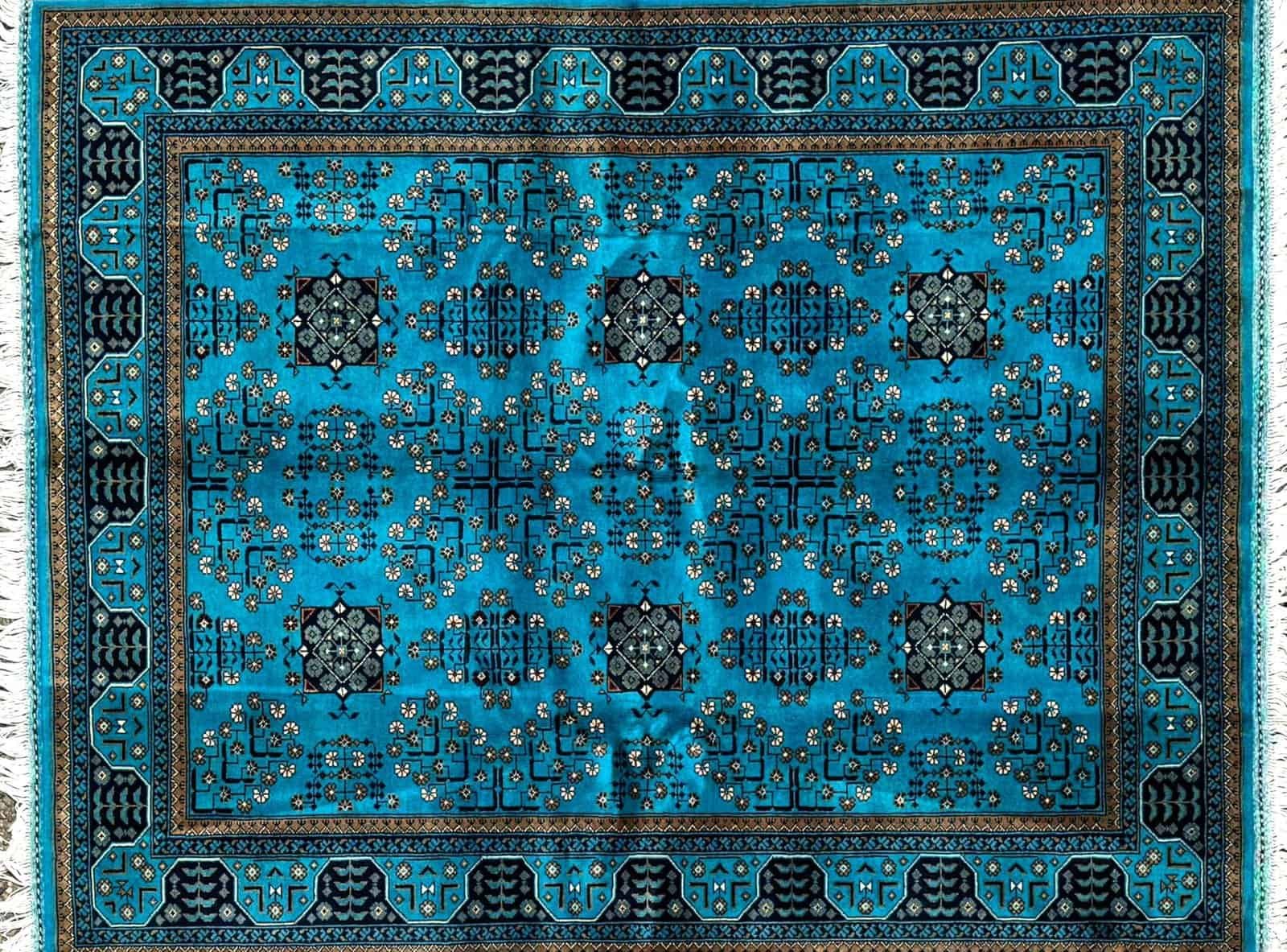 Rectangular Blue Rug With Geometric And Floral Patterns, Concentric Borders, And Central Motif.