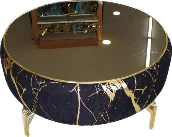 Round Coffee Table With Reflective Glass, Dark Blue And Gold Pattern, And Curved Metallic Legs.