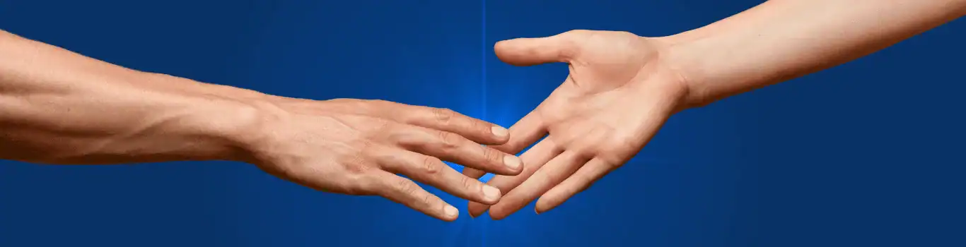 Two hands reaching towards each other against a blue background, with fingertips about to touch.