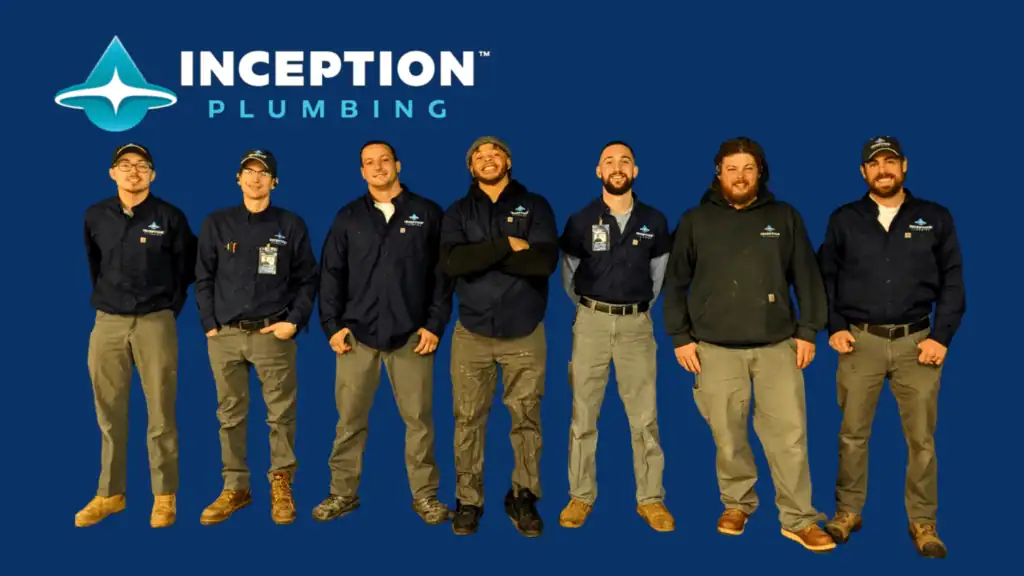Seven men in Inception Plumbing uniforms stand in a row against a blue background with the Inception Plumbing logo displayed in the top left corner, showcasing our team and current hiring opportunities for those interested in plumbing careers.